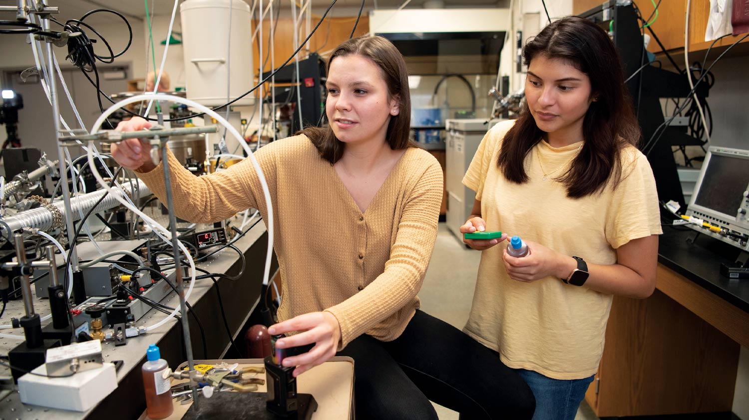 Jewel Cook '20 (left) and Ana Islas '20 connect an e-cigarette to a testing apparatus.