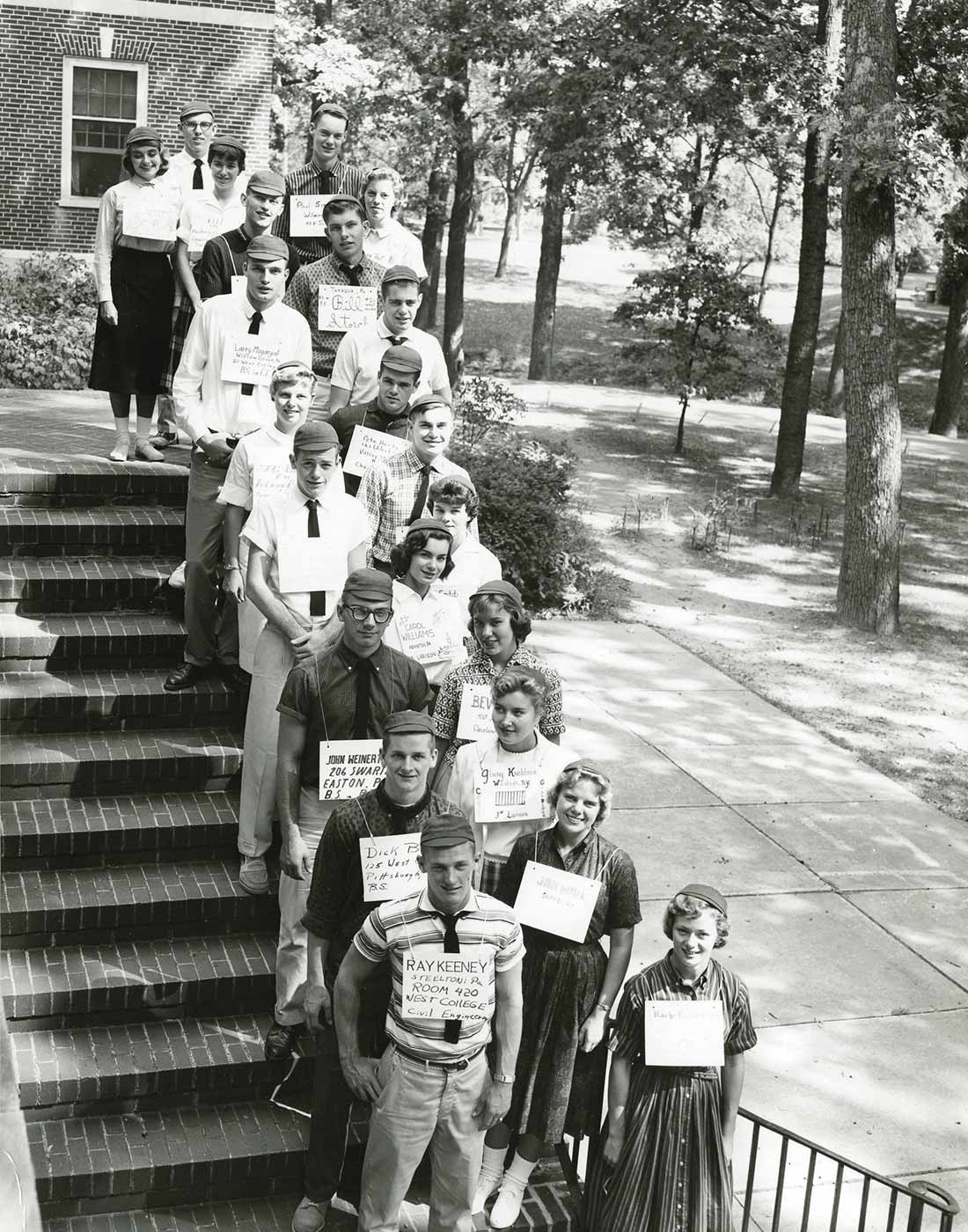 Vintage photograph of Bucknell students lined up  on stair with identifying cards around their neck.