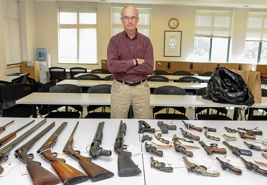 Peter Murchison ’73, P’02 with weapons voluntarily turned in at a gun buyback in Norwalk, Conn., in October 2019