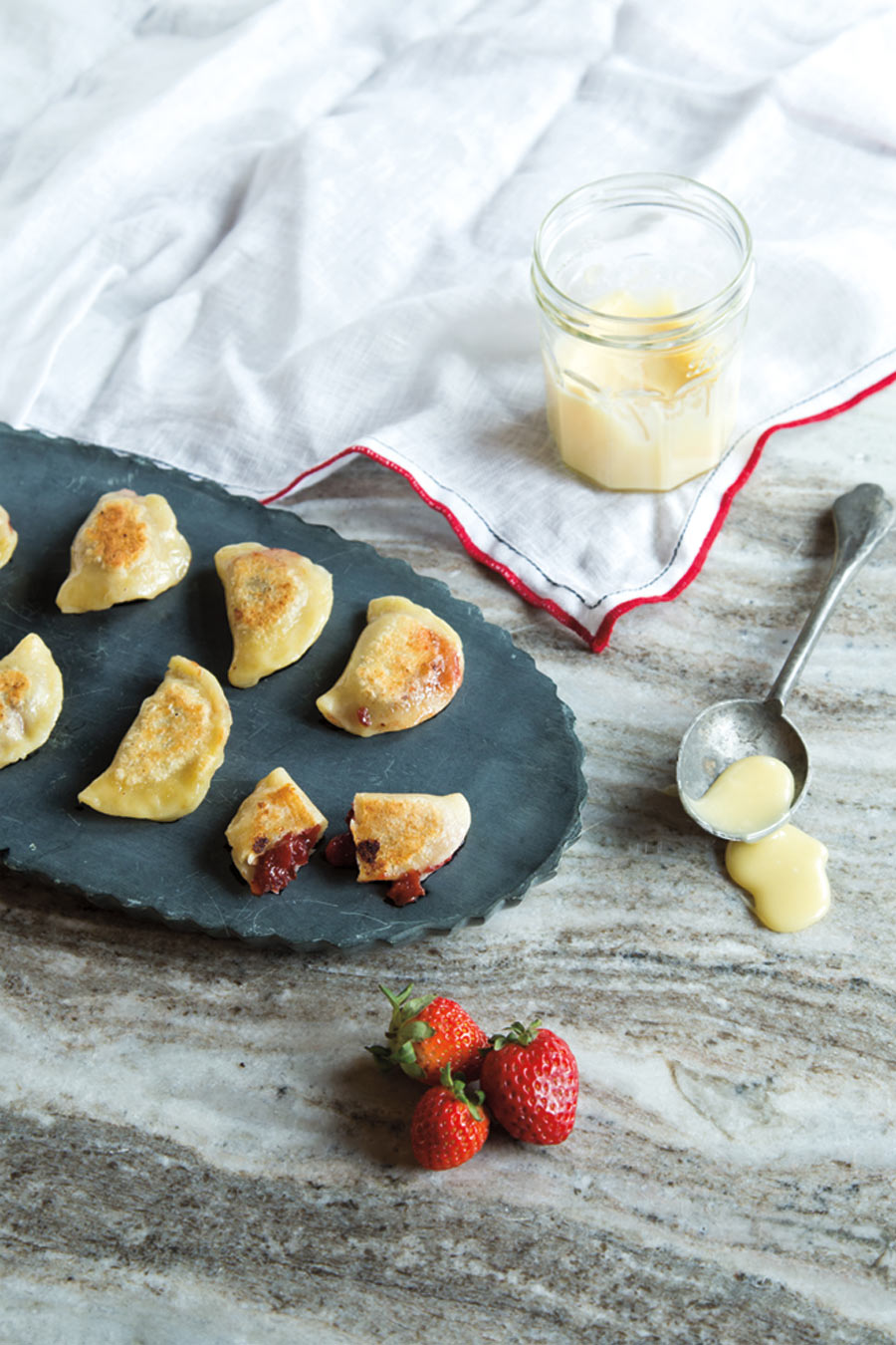 Plate of pierogies with fruit and glaze