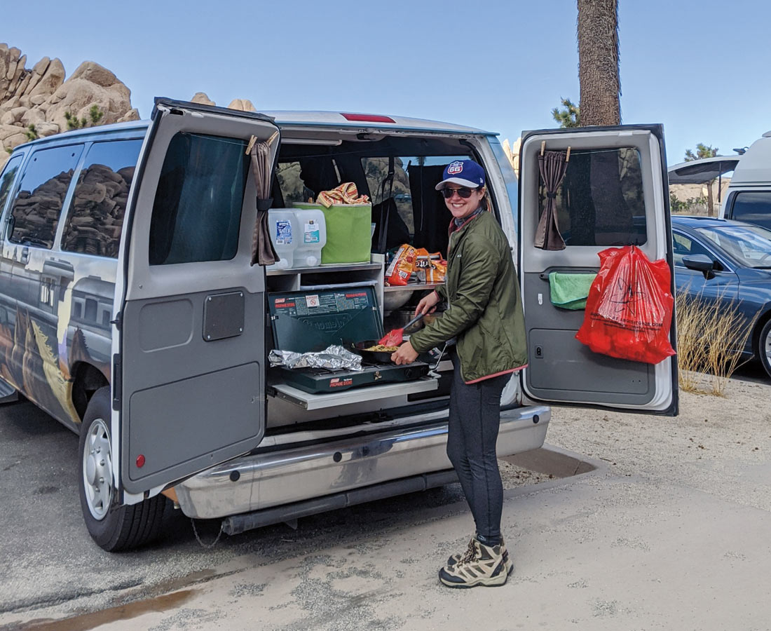 Casey Barber stands at van trunk cooking