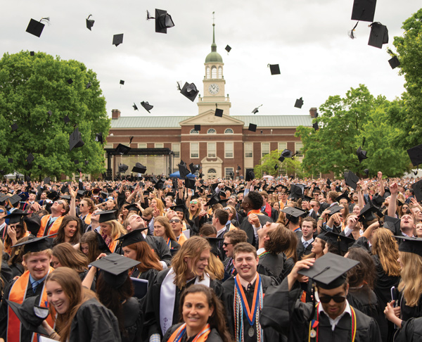Students tossing graduation caps in front of Bucknell university