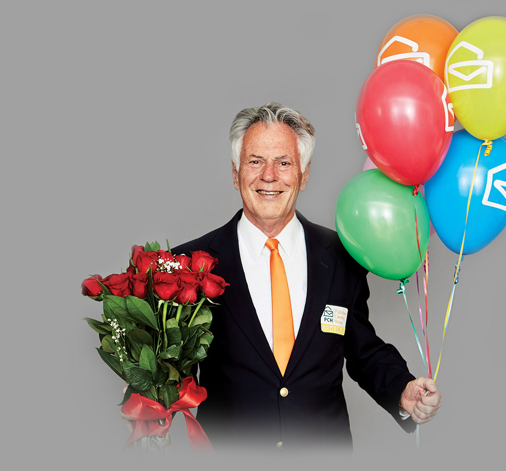 Dave Sayer smiling and holding roses and balloons