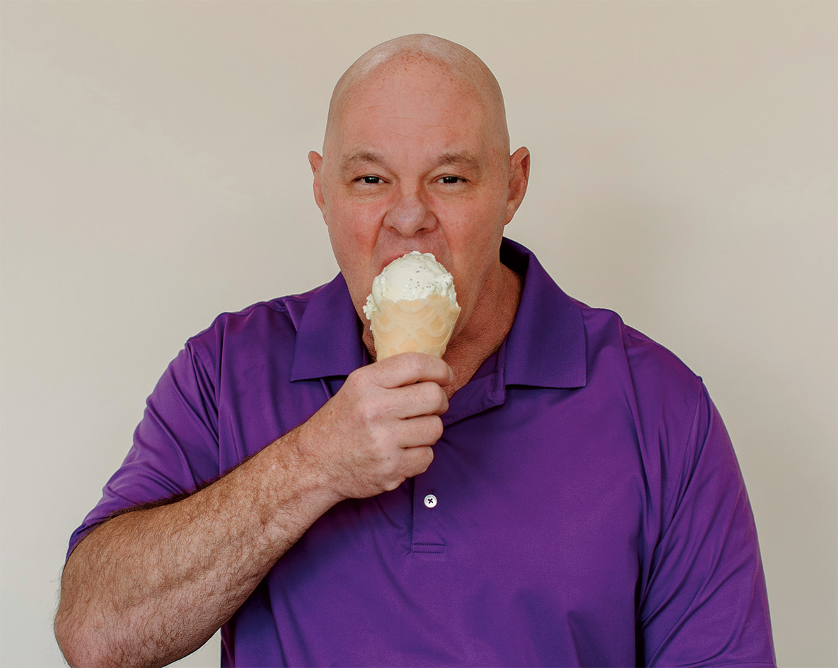 George Haymaker eating an ice cream cone in a purple polo shirt