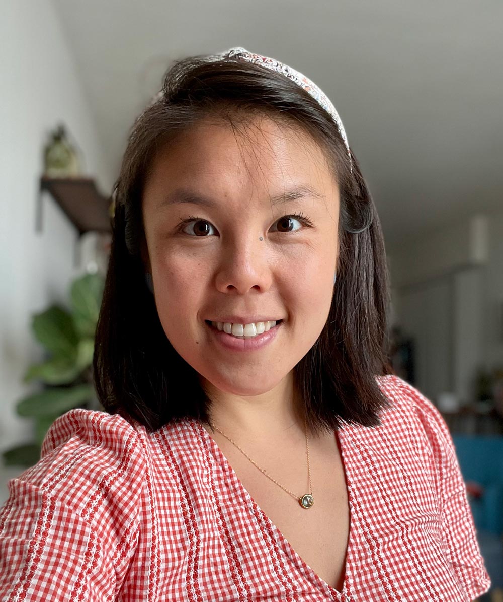 Chloe Chou takes a selfie, smiling an wearing a red plaid blouse