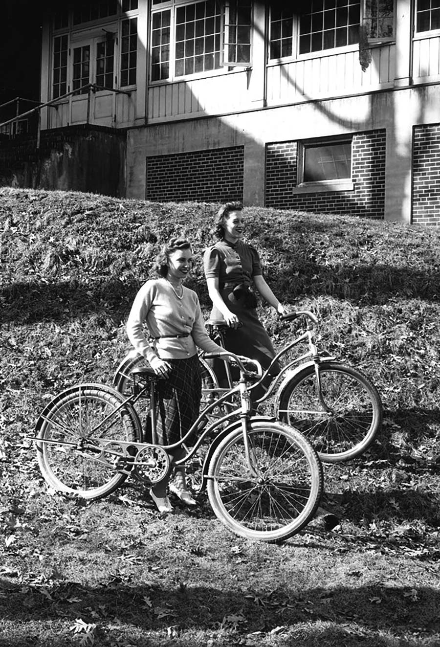 black and white photograph of two female Bucknell students with their bicycles