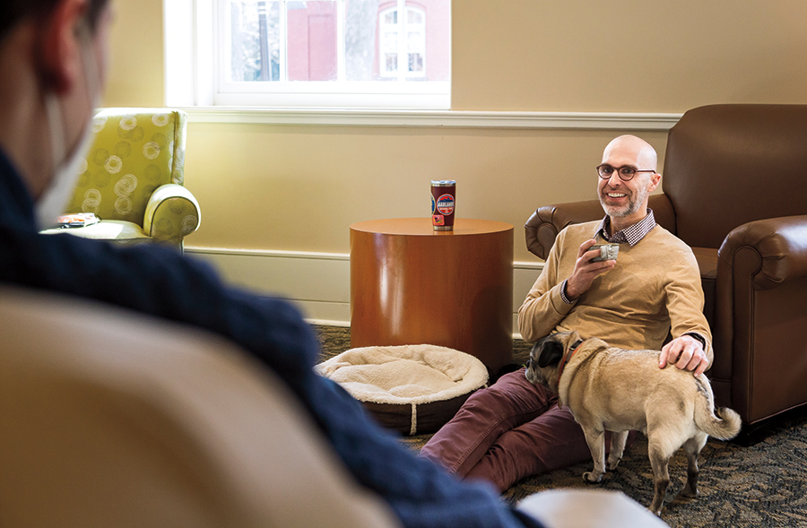Collin McKinney and Mort hang out with Andrei Bucaloiu ’22 in the Roberts Hall lounge during one of McKinney’s weekly coffee hours