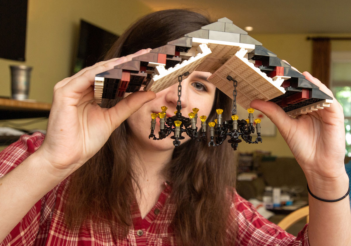 Woman holding a lego roof with chandeliers hanging