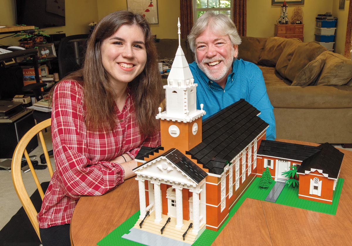 Man and woman posing with a lego replica of Rooke Chapel