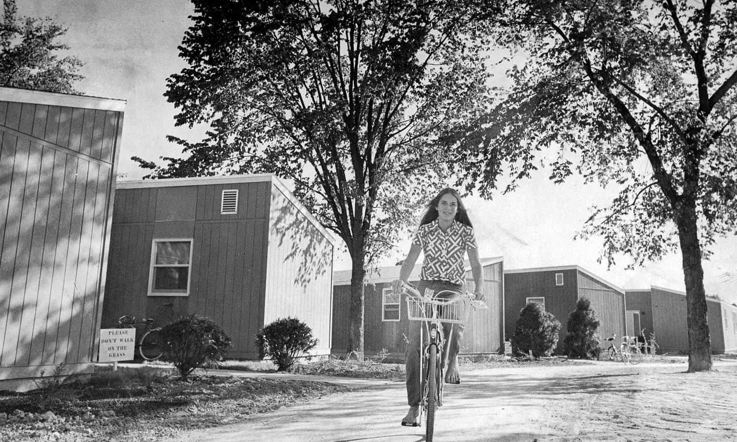 black and white photo of a young girl riding a bike