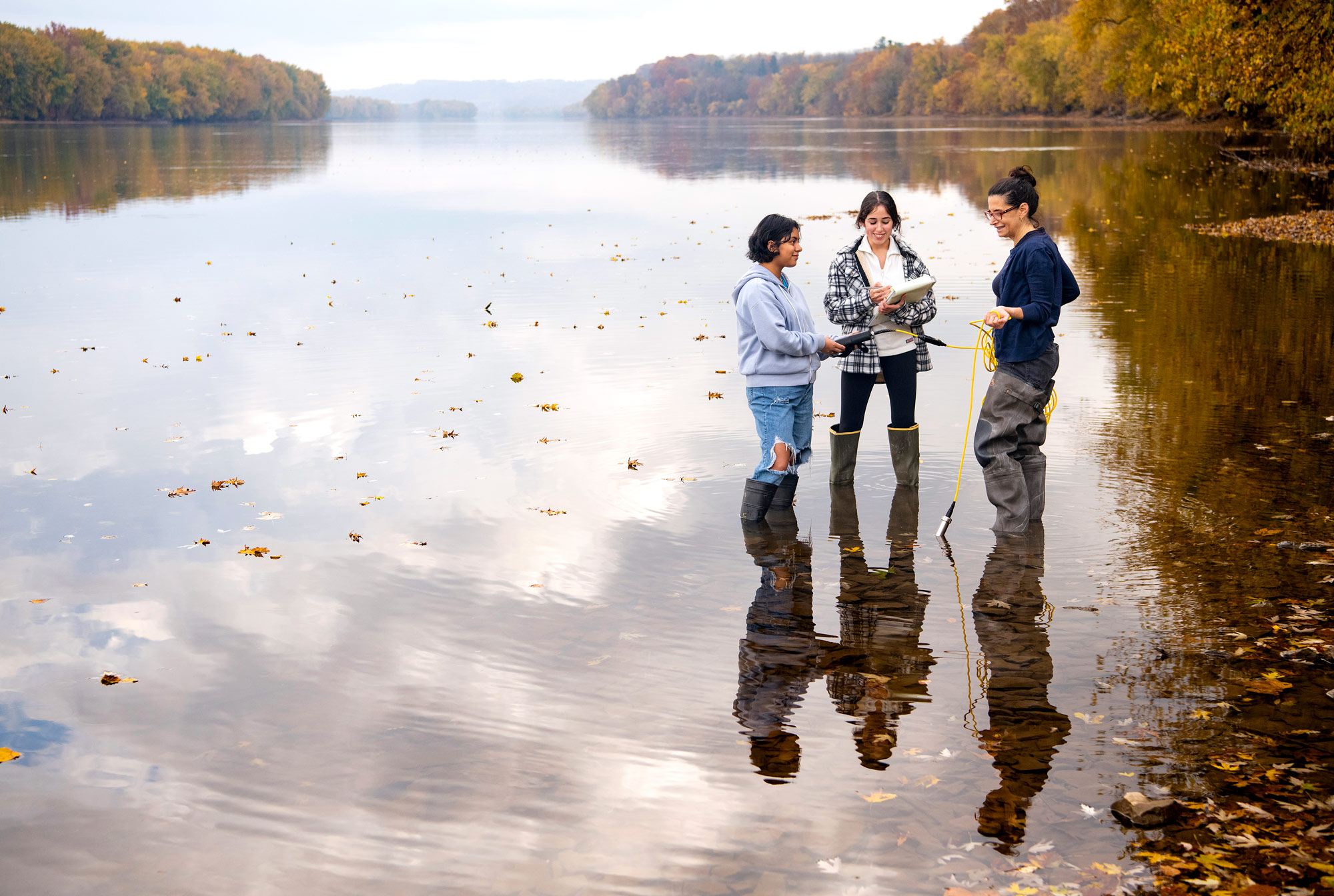 Demi Gonzalez, Melanie Gamboa and Professor Deborah Sills, civil & environmental engineering, test water in the Susquehanna River