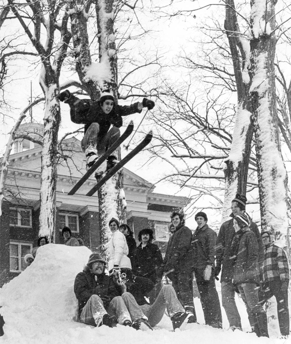 Peter Cree ’75 jumping off a snow ramp on skis