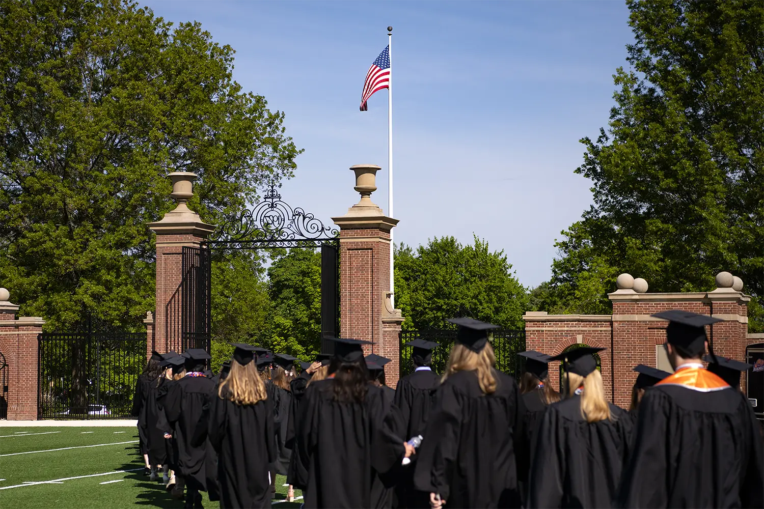 students in cap and gown leaving the gates of Bucknell