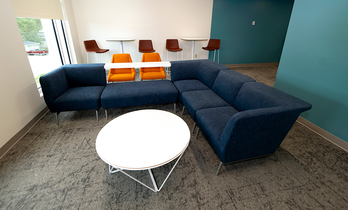 Blue sectional couch and a round white table in a campus housing facility