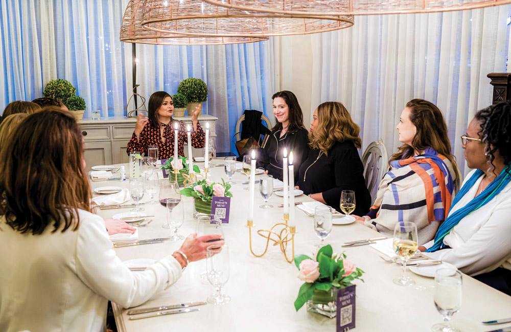Joya Dass at a dinner table with other women