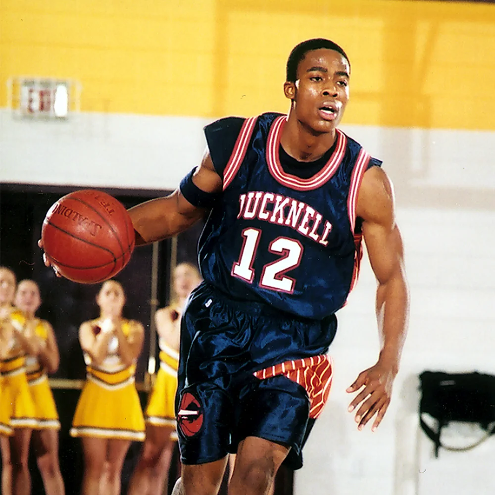 Bryan Bailey in a blue Bucknell basketball jersey and dribbling a basketball
