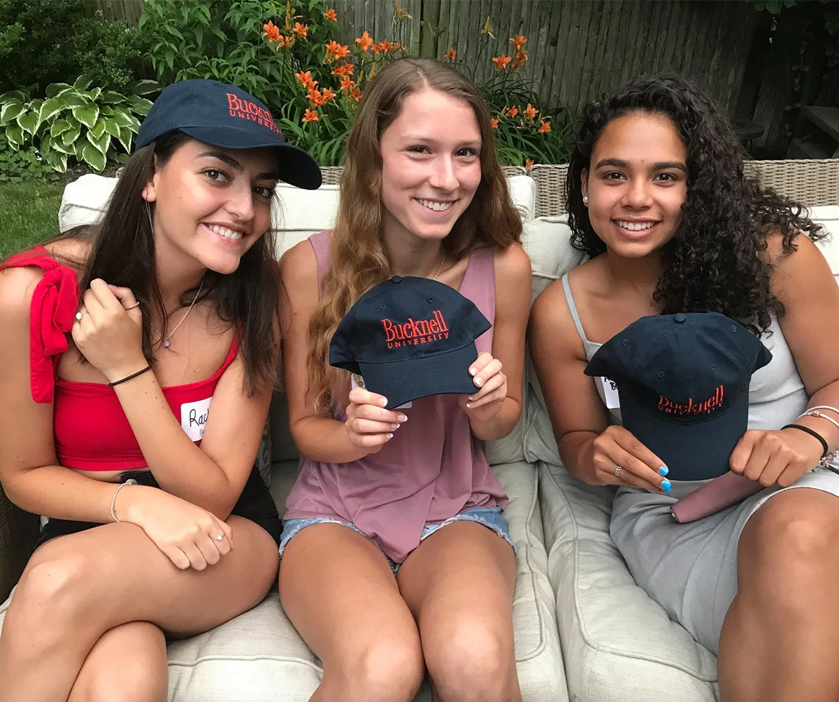 attendees of Bison Gathering posing with Bucknell hats