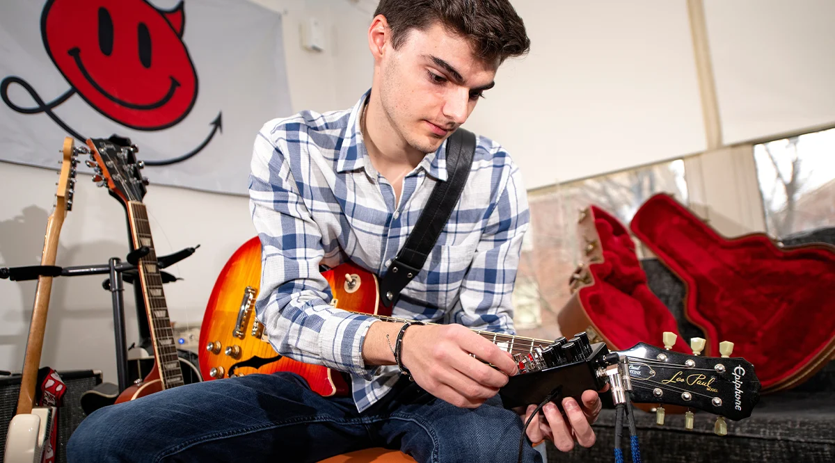 Thomas Smith fiddling with the knobs on his guitar pedal