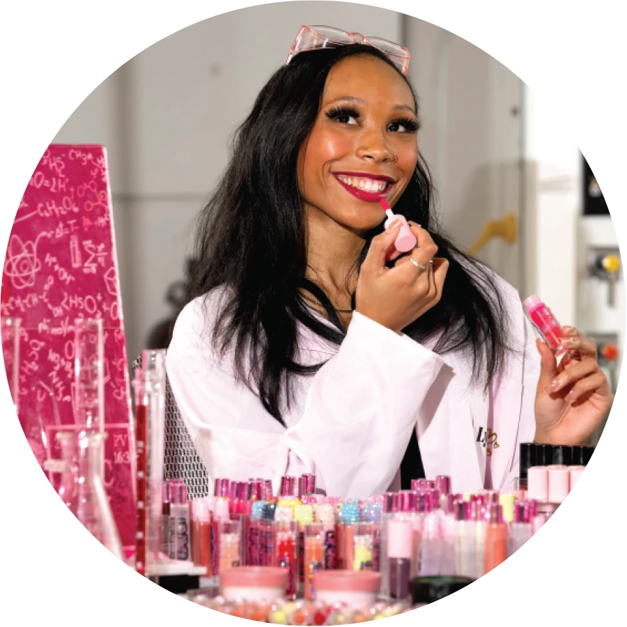 Lyric Abdul-Rasheed in lab coat with her products from her cosmetics start-up
