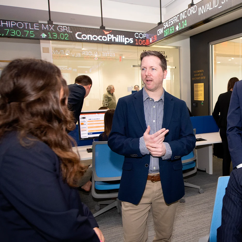 candid photo of Professor Curtis Nicholls speaking to attendee at a Freeman College personal finance seminar