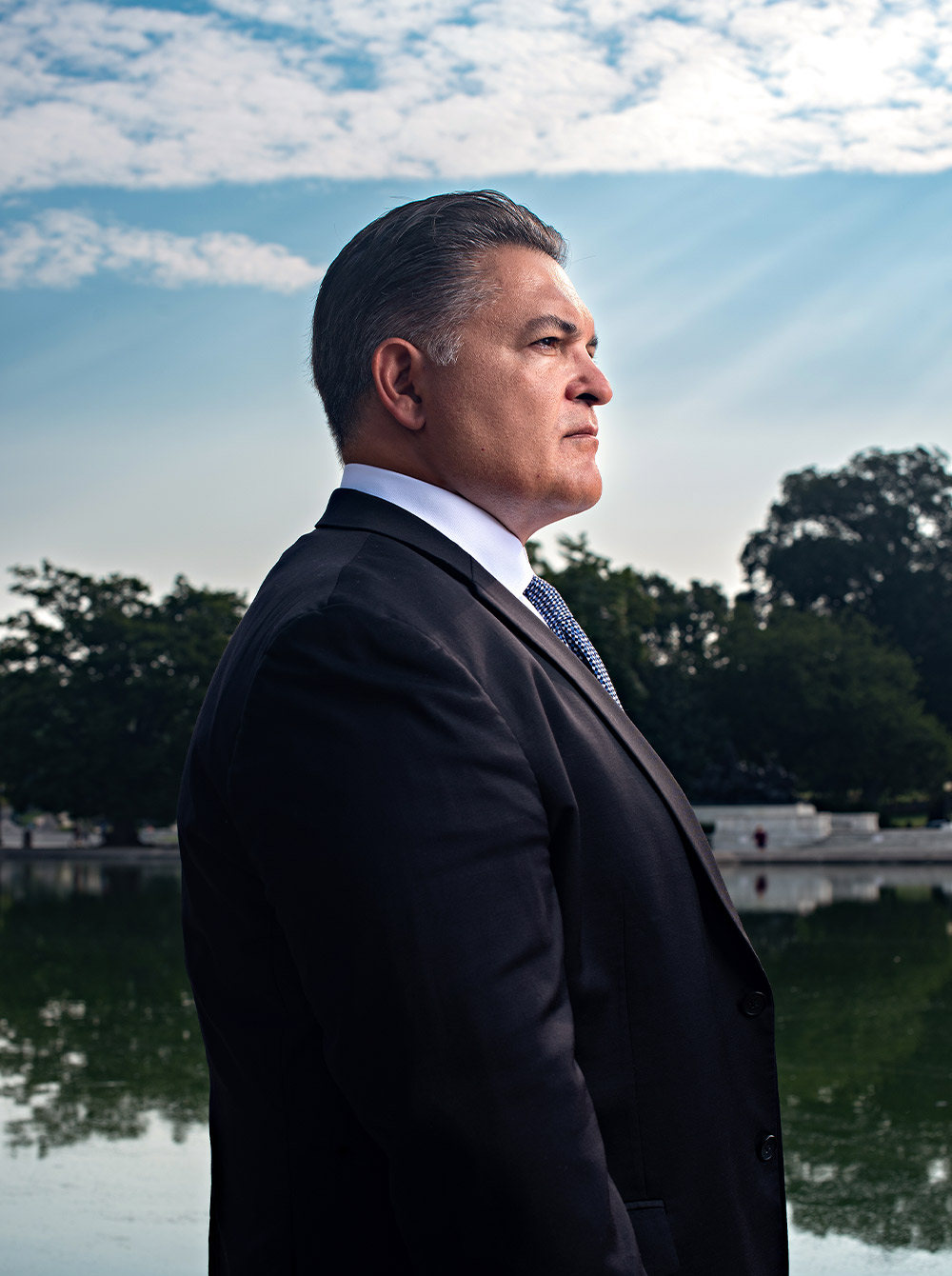 profile portrait of Rob Canestrari wearing a suit and standing against the Capitol Reflecting Pool