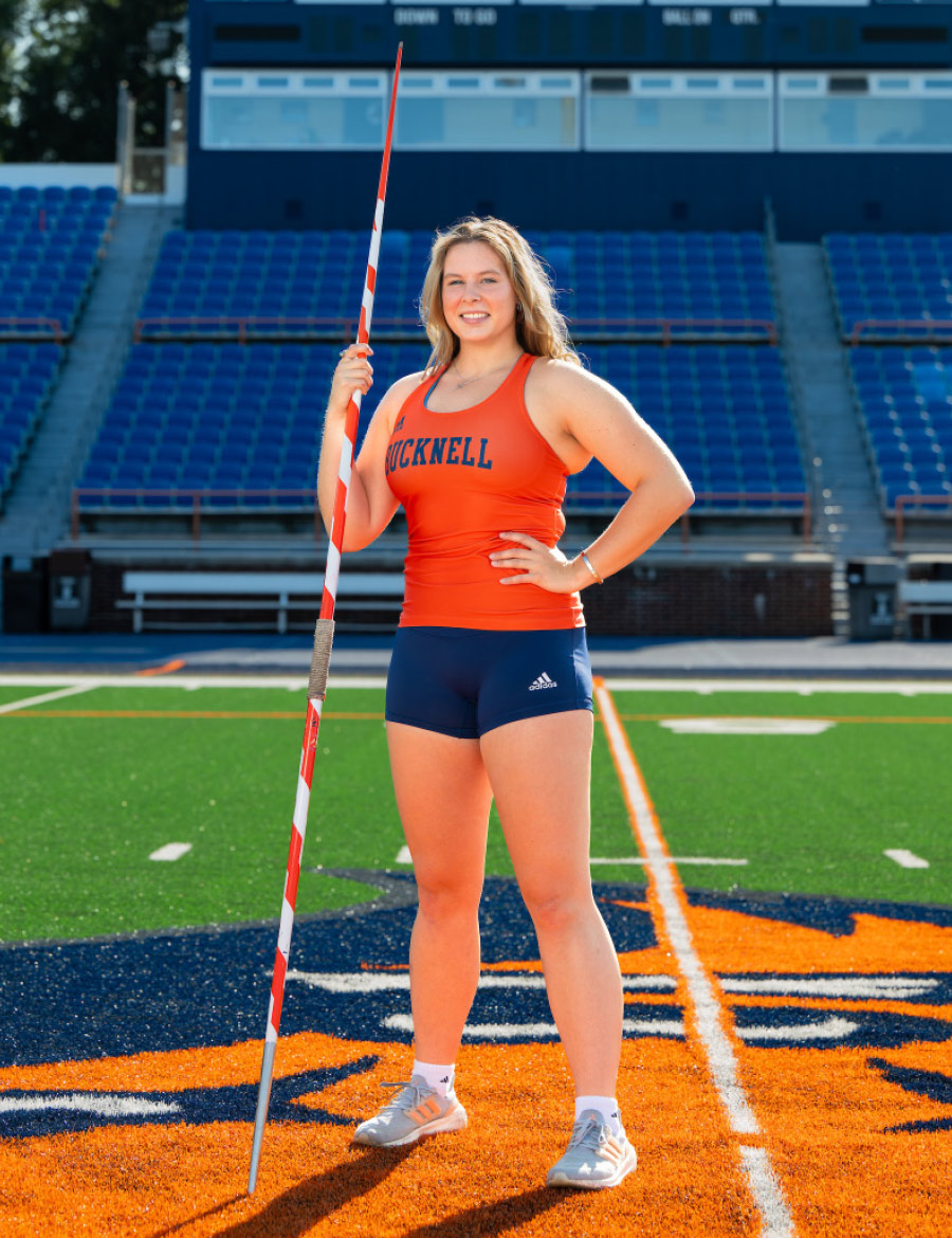 Evelyn Bliss holding javelin in track uniform on field