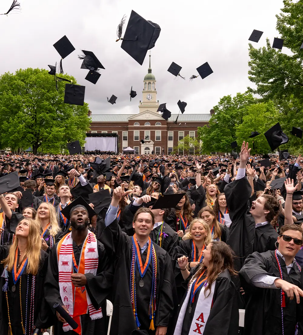 color image action shot of Bucknell grads tossing their caps in celebration