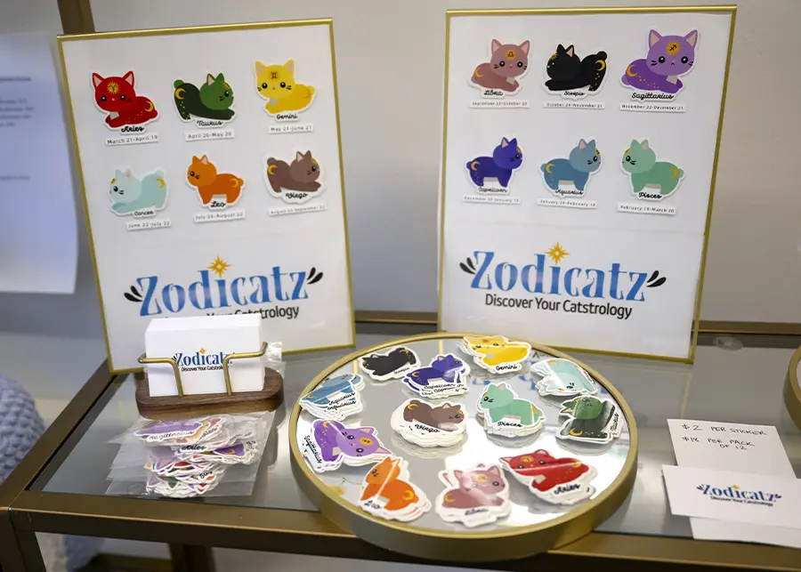 Zodicatz stickers and display rack on a shelf