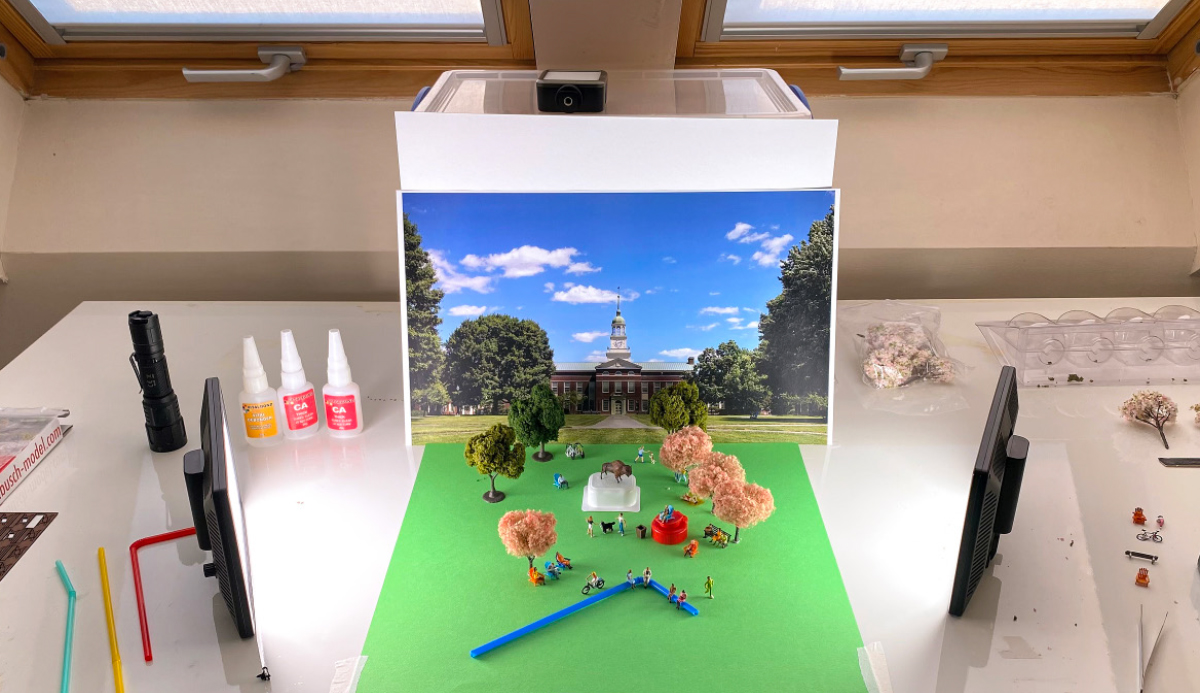 plastic mini model of Bucknell courtyard on working table with tools and light surrounding it